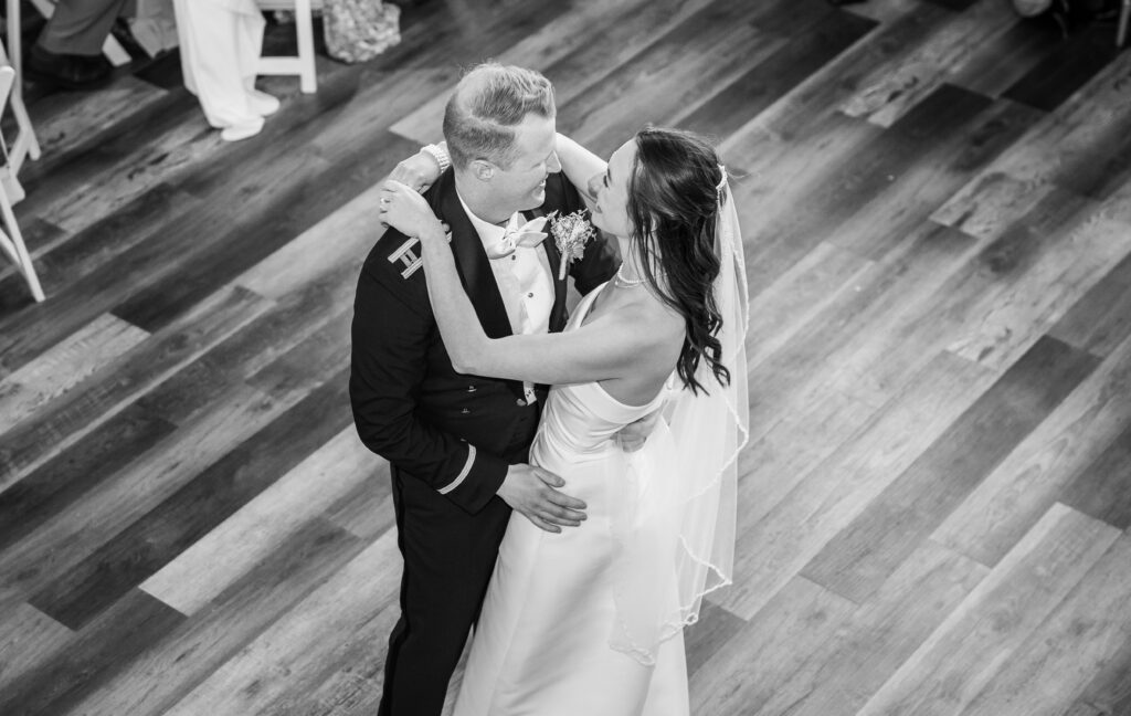 Open and airy barn wedding reception space at Halcyon Watson with polished wood floors and crystal chandeliers.