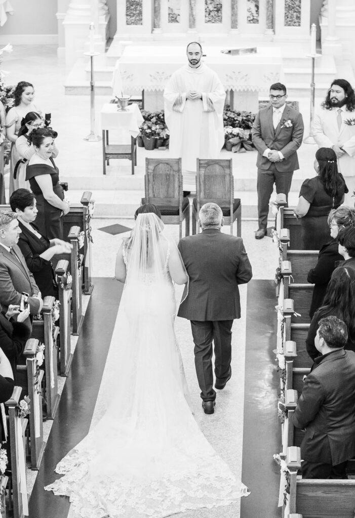 Bride with lace-trimmed veil flowing behind her