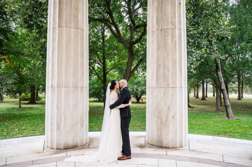 Bride and groom kissing during their intimate ceremony at the DC War Memorial.