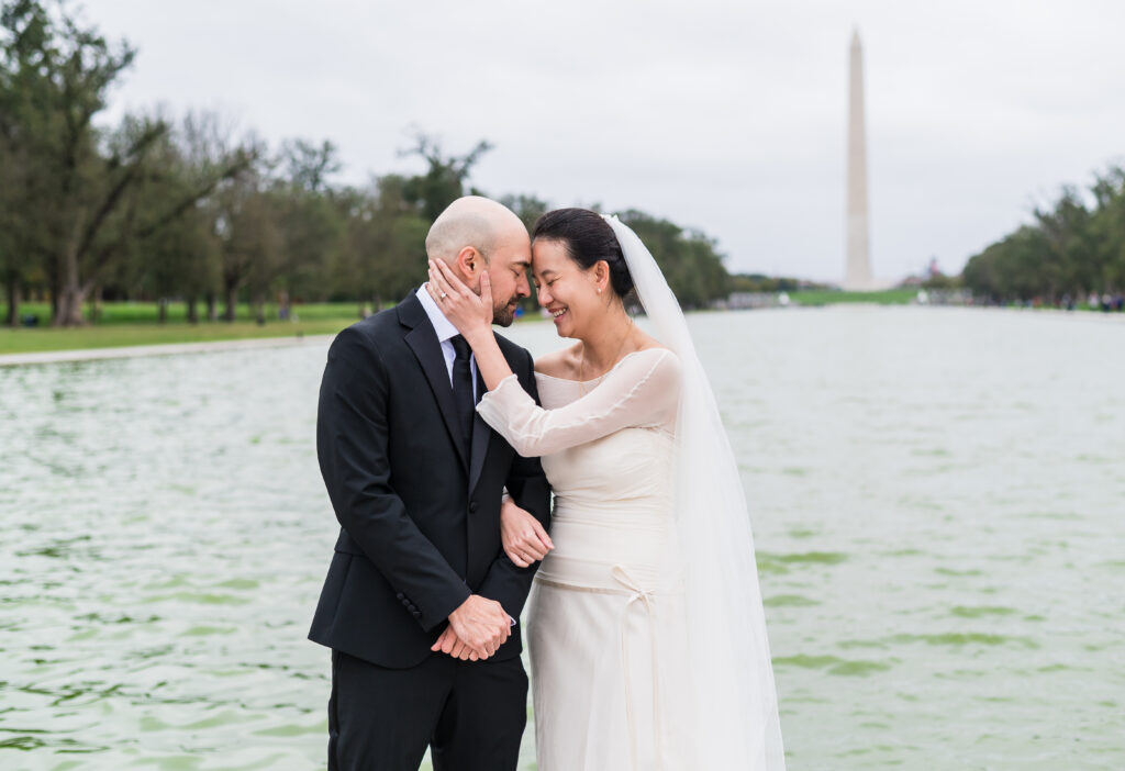 Bride and groom walking by the Reflecting Pool for wedding portraits in Washington, D.C.
