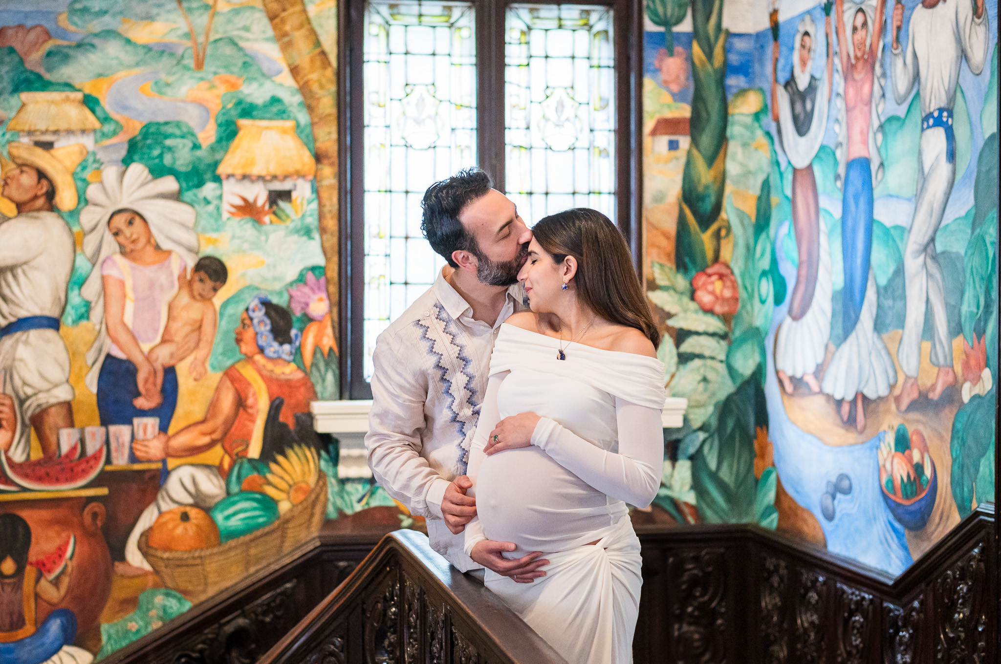 Expecting couple cuddling in for a forehead kiss during a maternity session at the Mexican Cultural Institute in Washington D.C.