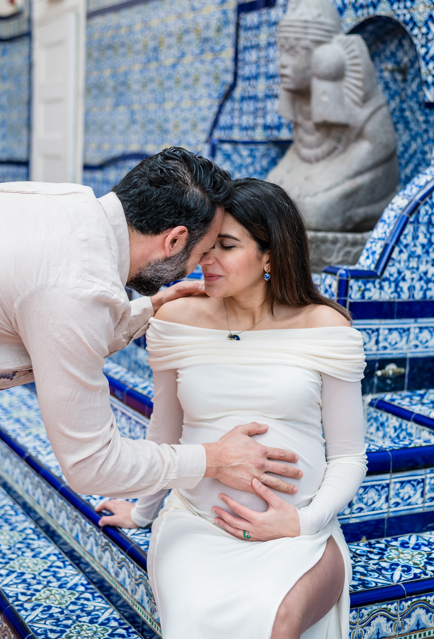 Couple holding belly during an elegant maternity session at the Mexican Cultural Institute.